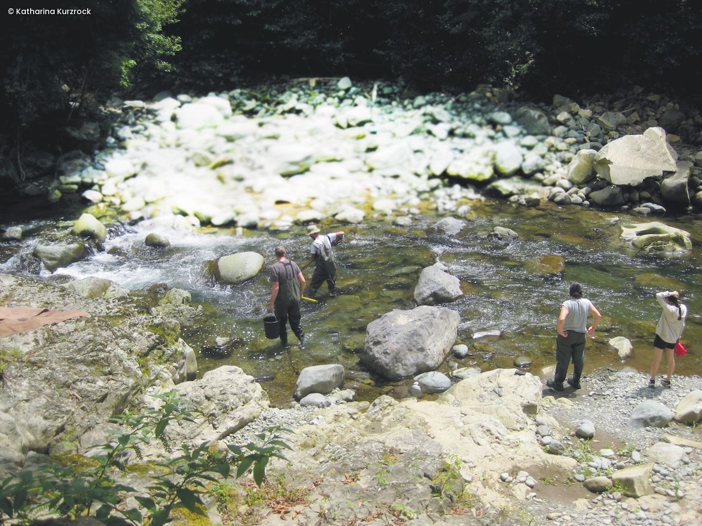Zwei Forscher stehen in einem Bauchlauf in Regenkleidung
